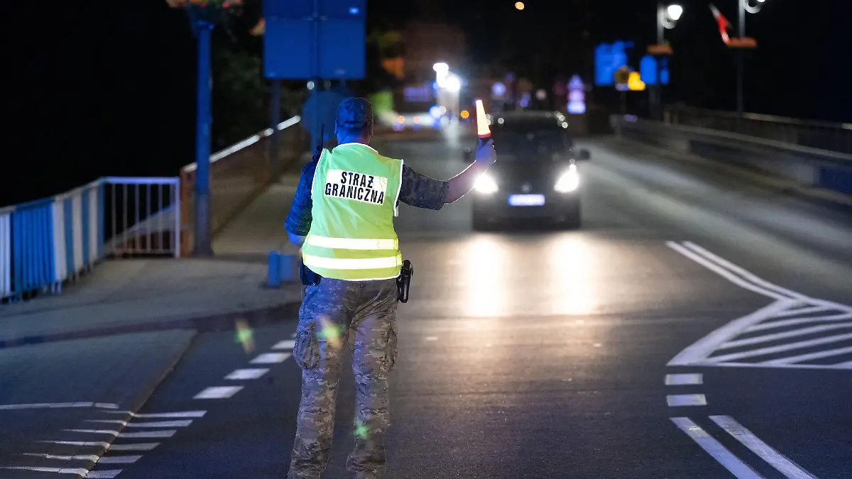 Ein polnischer Grenzschützer steht hinter der Stadtbrücke von Görlitz und winkt ein Fahrzeug zur Kontrolle raus. Polen hat vorübergehend die Grenzkontrollen an der deutsch-polnischen Grenze wieder aufgenommen. (Foto aktuell)
