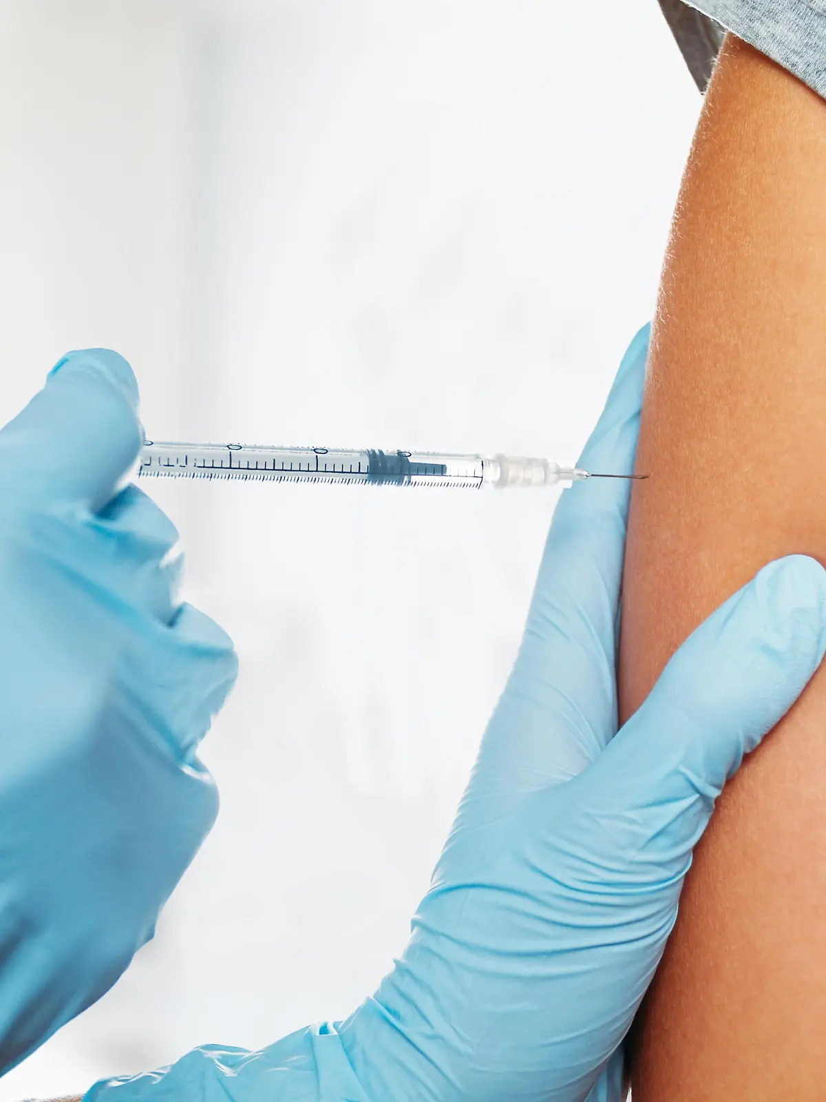 Nurse makes vaccination in the shoulder of patient in a clinic