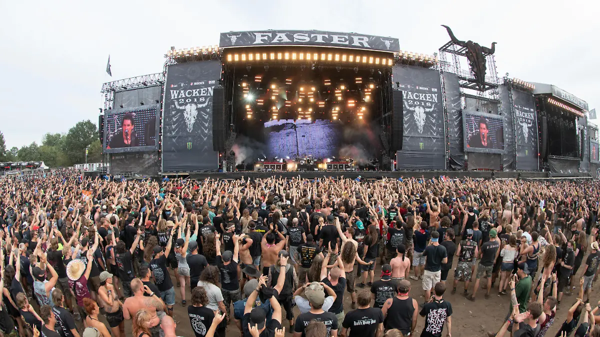 04.08.2018, Schleswig-Holstein, Wacken: Zahlreiche Festivalbesucher stehen vor einer der Hauptbühnen des Wacken Open Air Festivals. Das nach Veranstalterangaben größte Heavy-Metal Festival der Welt besuchen 75000 Menschen. Foto: Daniel Reinhardt/dpa +++ dpa-Bildfunk +++