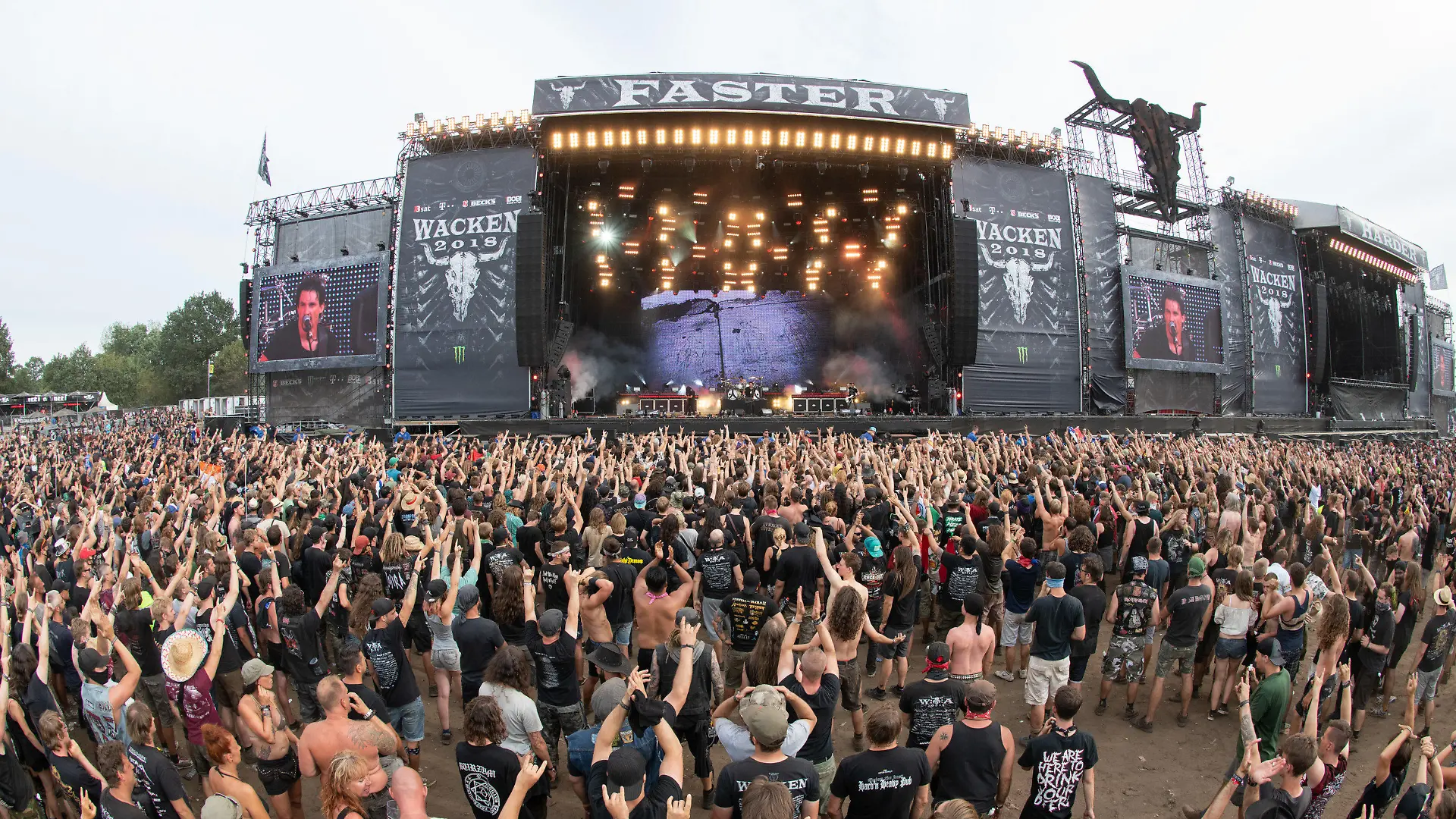04.08.2018, Schleswig-Holstein, Wacken: Zahlreiche Festivalbesucher stehen vor einer der Hauptbühnen des Wacken Open Air Festivals. Das nach Veranstalterangaben größte Heavy-Metal Festival der Welt besuchen 75000 Menschen. Foto: Daniel Reinhardt/dpa +++ dpa-Bildfunk +++