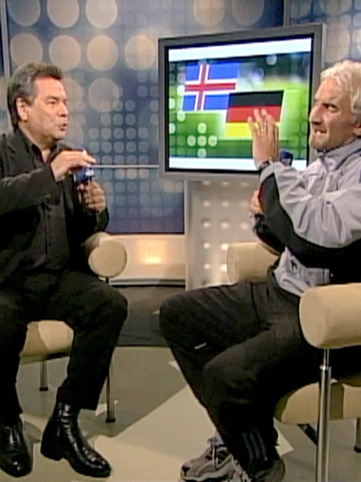 ARCHIV - 07.09.2003, Berlin: Das vom Video abgenommene Bild zeigt den damaligen Teamchef der deutschen Fußball-Nationalmannschaft, Rudi Völler, am 06.09.2003 in Reykjavik bei einem Interview im ARD-Studio im Gespräch mit Moderator Waldemar Hartmann. Nach dem 0:0 in der EM-Qualifikation gegen Island rastet der Teamchef vor laufender Kamera regelrecht aus. Hartmann haute er bei seiner Wutrede seinerzeit einen unvergesslichen Satz um die Ohren: «Du sitzt hier locker bequem auf deinem Stuhl, hast drei Weizenbier getrunken und bist schön locker.» (Bestmögliche Qualität) Foto: Ard/Ndr/ARD/NDR/dpa +++ dpa-Bildfunk +++