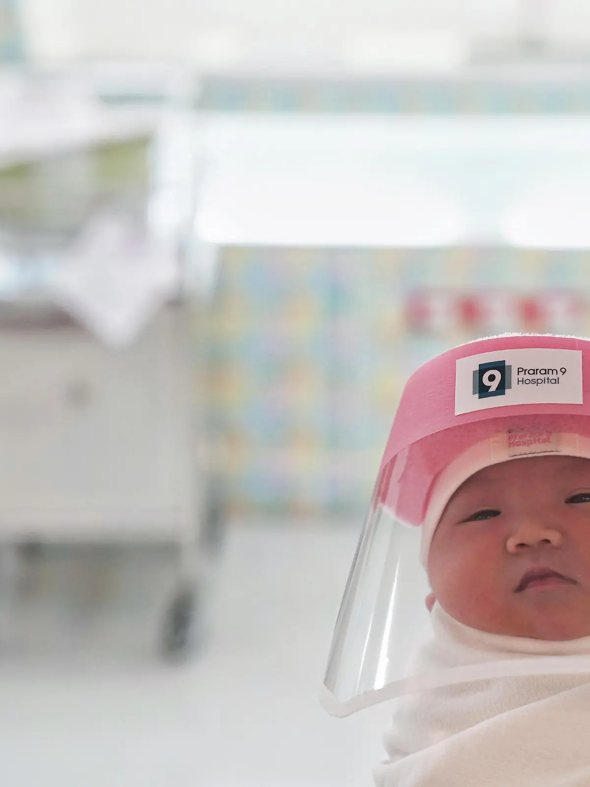 A newborn baby is seen wearing a protective face shield during the coronavirus disease (COVID-19) outbreak at the Praram 9 hospital in Bangkok, Thailand, April 9, 2020. REUTERS/Athit Perawongmetha  