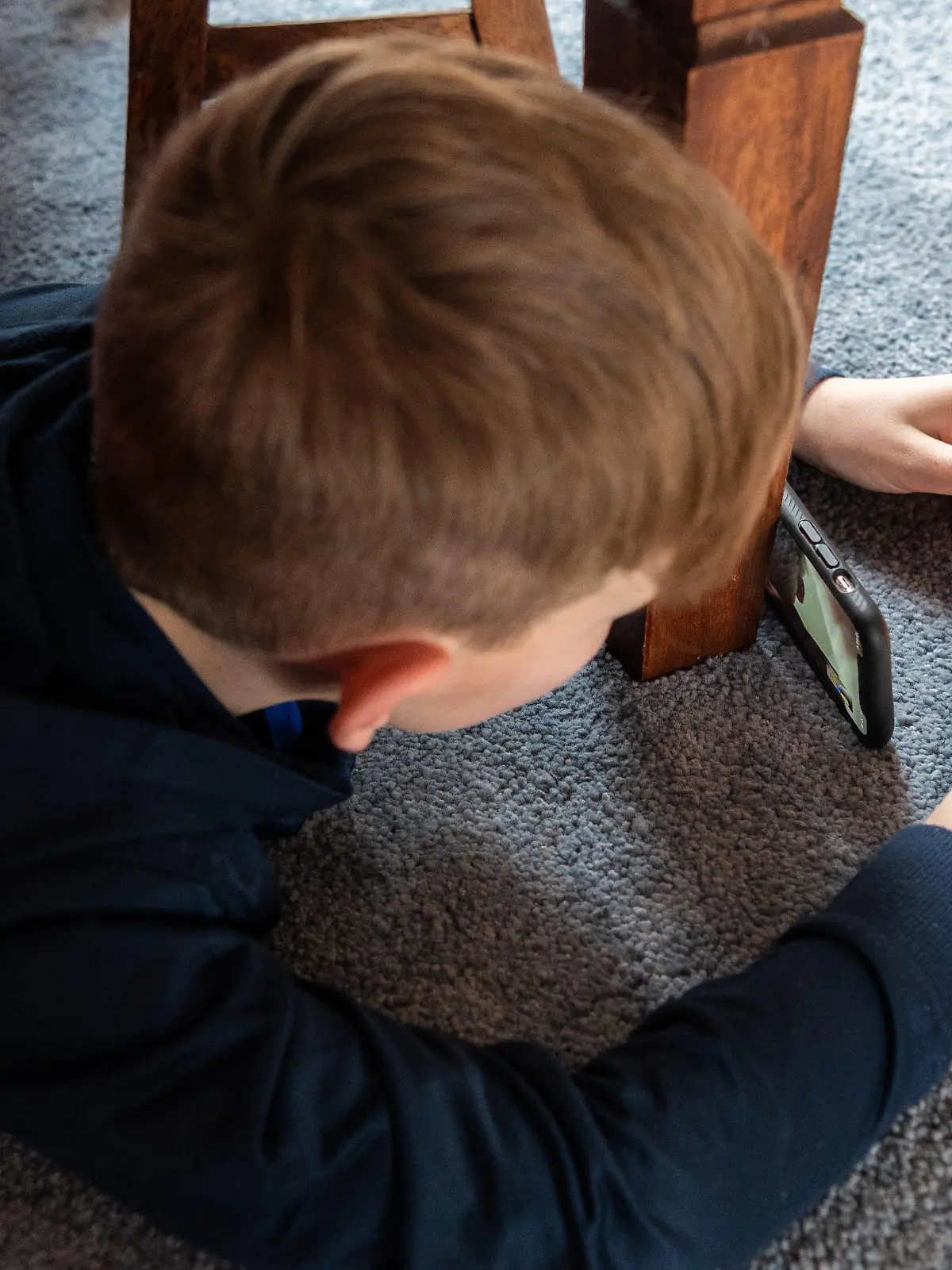 ARCHIV - 20.03.2020, Sachsen, Dresden: Ein Junge spielt ein Videospiel auf seinem Smartphone und überträgt es mit einem zweiten Handy per Facetime zu seinem Freund. (zu dpa "Macht das Smartphone krank? - Eltern in Sorge um ihre Kinder") Foto: Robert Michael/dpa-Zentralbild/dpa +++ dpa-Bildfunk +++
