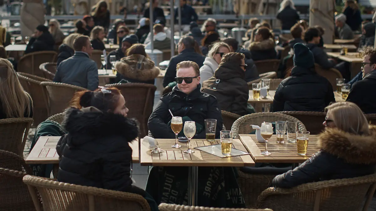 04.04.2020, Schweden, Stockholm: Menschen sitzen vor einem Restaurant am Bürgerplatz. Die Schweden gehen bisher mit freizügigeren Maßnahmen als andere europäische Länder gegen die Corona-Pandemie vor, verfolgen aber ebenso das Ziel, die Ausbreitung des Virus möglichst zu verlangsamen. Foto: Andres Kudacki/AP/dpa +++ dpa-Bildfunk +++