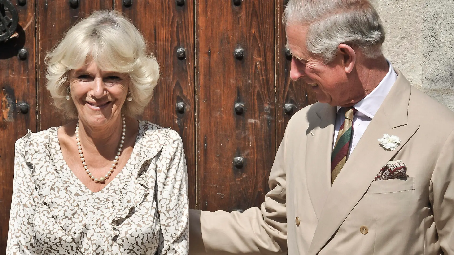 ARCHIV - 17.07.2013, Großbritannien, Lostwithiel: Der britische Thronfolger Prinz Charles, legt seine Hand auf den Rücken seiner Frau Camilla, Herzogin von Cornwall, vor dem Herzogtumspalast in Lostwithiel an Camillas Geburtstag. Vor 15 Jahren haben Prinz Charles und Camilla Parker Bowles geheiratet. Erst kurz vor ihrem Hochzeitstag an diesem Donnerstag, 09.04.2020, waren sie wieder vereint, denn wegen der Corona-Krise mussten beide vorübergehend getrennt in Isolation leben. (zu dpa "Ein Herz und eine Krone? - Charles und Camilla 15 Jahre verheiratet") Foto: Ben Birchall/PA Wire/dpa +++ dpa-Bildfunk +++