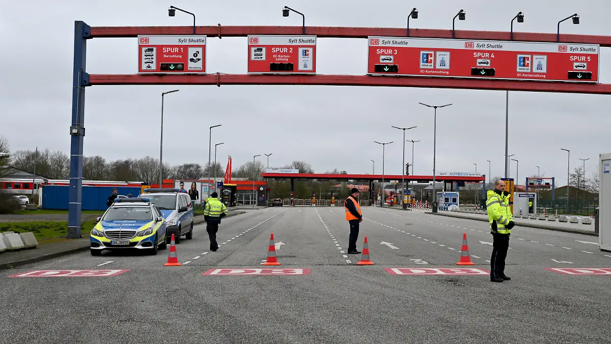 16.03.2020, Schlewig-Holstein, Niebüll: Polizisten stehen an der Einfahrt zur Verladestation nach Sylt. Der Zugang zu den Inseln ist wegen der Verbreitung des Coronavirus nur noch Einwohnern und Berufspendlern gestattet. Foto: Carsten Rehder/dpa +++ dpa-Bildfunk +++
