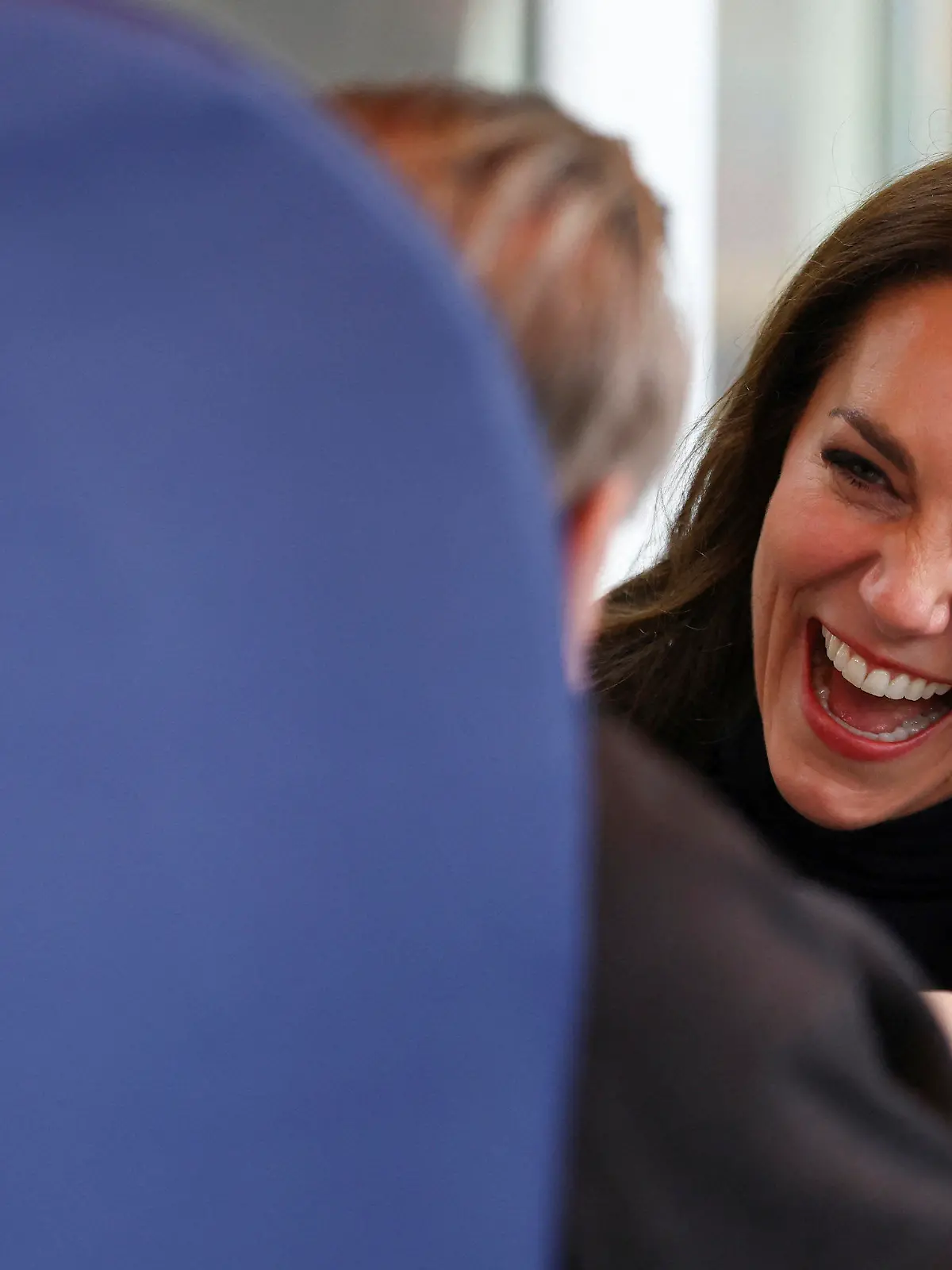 GRAFIK - 21.02.2023, Großbritannien, Slough: Die britische Prinzessin Kate von Wales (r) lacht während ihres Besuchs im Oxford House Nursing Home, wo sie mit Mitarbeitern und Bewohnern zusammentraf. Foto: Hannah Mckay/POOL REUTERS/AP/dpa +++ dpa-Bildfunk +++