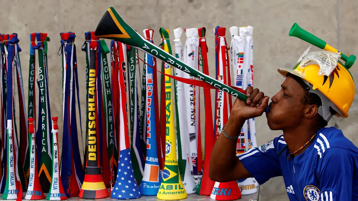 FILE PHOTO: ON THIS DAY -- March 26  March 26, 2010     SOCCER - South African street vendor, Mpho Qhalane, blows a Vuvuzela outside the FNB Stadium during a game between Johannesburg Soccer Legend and City of Johannesburg municipal workers ahead of the 2010 FIFA World Cup in South Africa.     The FNB stadium hosted the inaugural and final matches of the 2010 World Cup, which won by Spain, who lifted their maiden title after beating Netherlands 1-0 in the final thanks to an extra time goal from Andres Iniesta.     The Vuvuzela, a plastic horn that produces a loud droning sound, was one of the symbols of the World Cup, but was banned after by venues including Wembley Stadium, Lord's Cricket Ground and Wimbledon, as well as by world soccer body FIFA. REUTERS/Siphiwe Sibeko/File Photo
