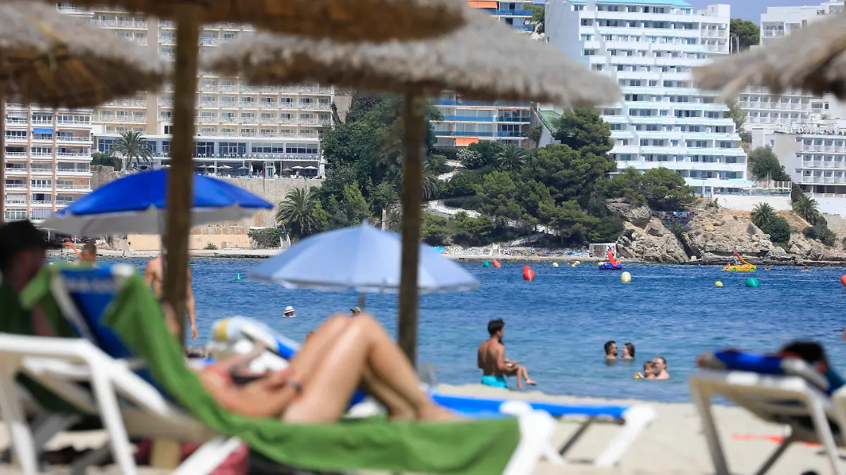 17.08.2023, Spanien, Calvia: Menschen genießen den Tag am Strand in Magaluf. Polizei und Justiz müssen sich auf Mallorca erneut mit einer mutmaßlichen Gruppenvergewaltigung beschäftigen. Foto: Clara Margais/dpa +++ dpa-Bildfunk +++