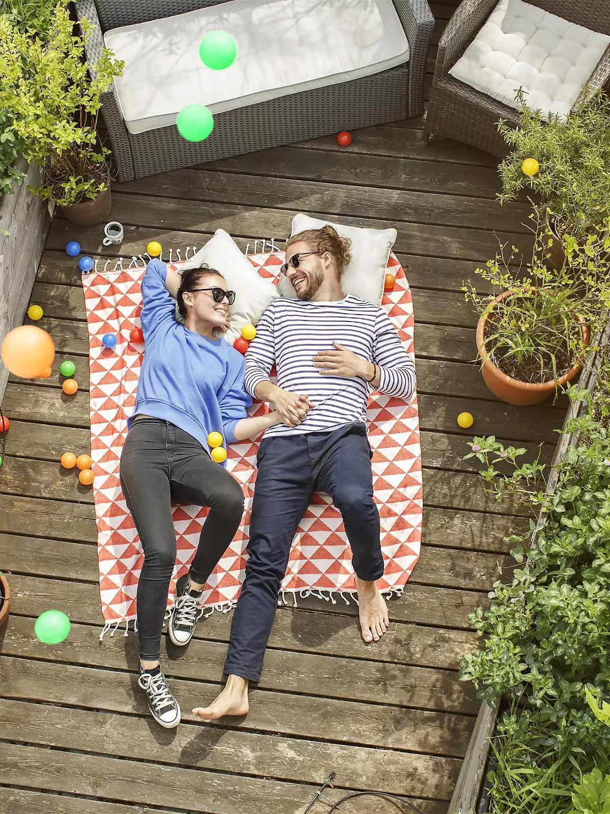 Young couple relaxing on their balcony, lying on blanket with arms around model released Symbolfoto property released PUBLICATIONxINxGERxSUIxAUTxHUNxONLY PESF01171  