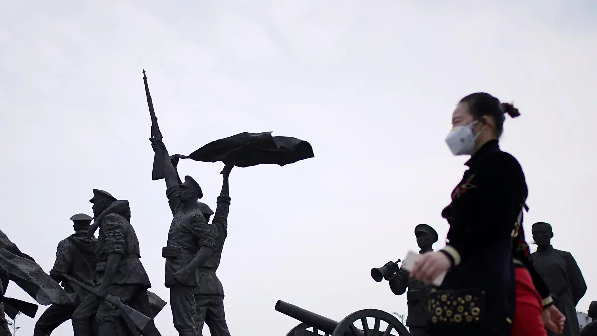 A resident wearing a face mask walks past statue symbolising Xinhai Revolution, a revolution that toppled China's last emperor in 1911, in Wuhan, Hubei province, the epicentre of China's coronavirus disease (COVID-19) outbreak, April 6, 2020. REUTERS/Aly Song