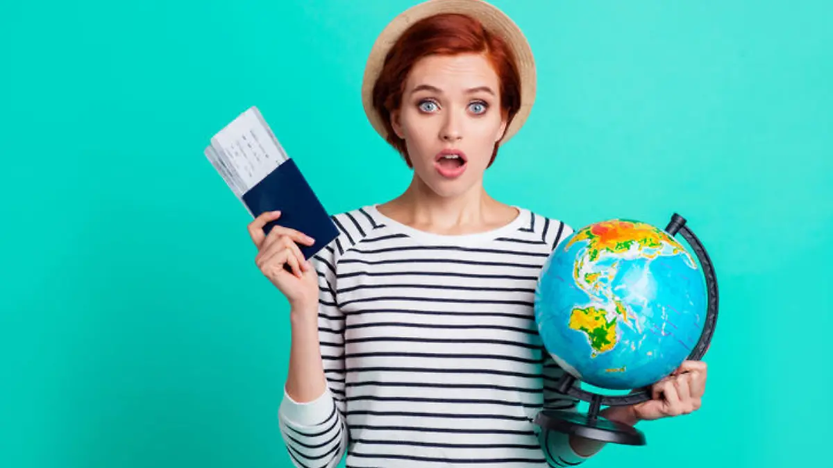 Earth people rest relax resort recreation hot weather concept. Afraid panic stupor speechless with open mouth she her holding document two train tickets globe in hand isolated turquoise background (Earth people rest relax resort recreation hot weathe