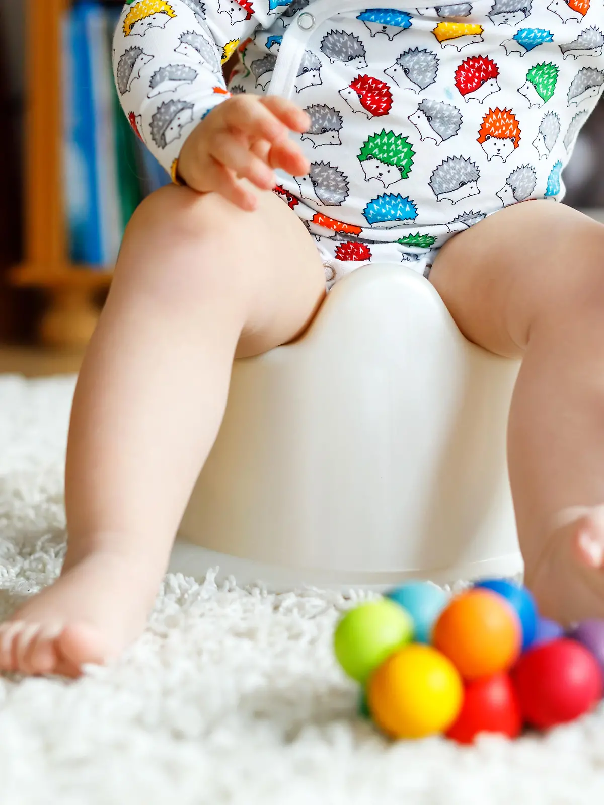 Baby sitzt auf dem Töpfchen und spielt
