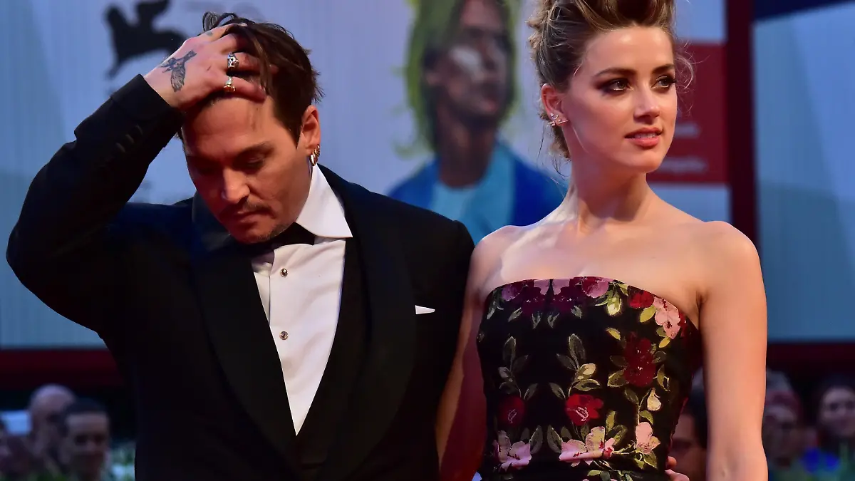 US actress Amber Heard arrives with her husband US actor Johnny Depp for the screening of the movie "The Danish Girl" presented in competition at the 72nd Venice International Film Festival on September 5, 2015 at Venice Lido. AFP PHOTO / GIUSEPPE CACACE (Photo credit should read GIUSEPPE CACACE/AFP/Getty Images)
