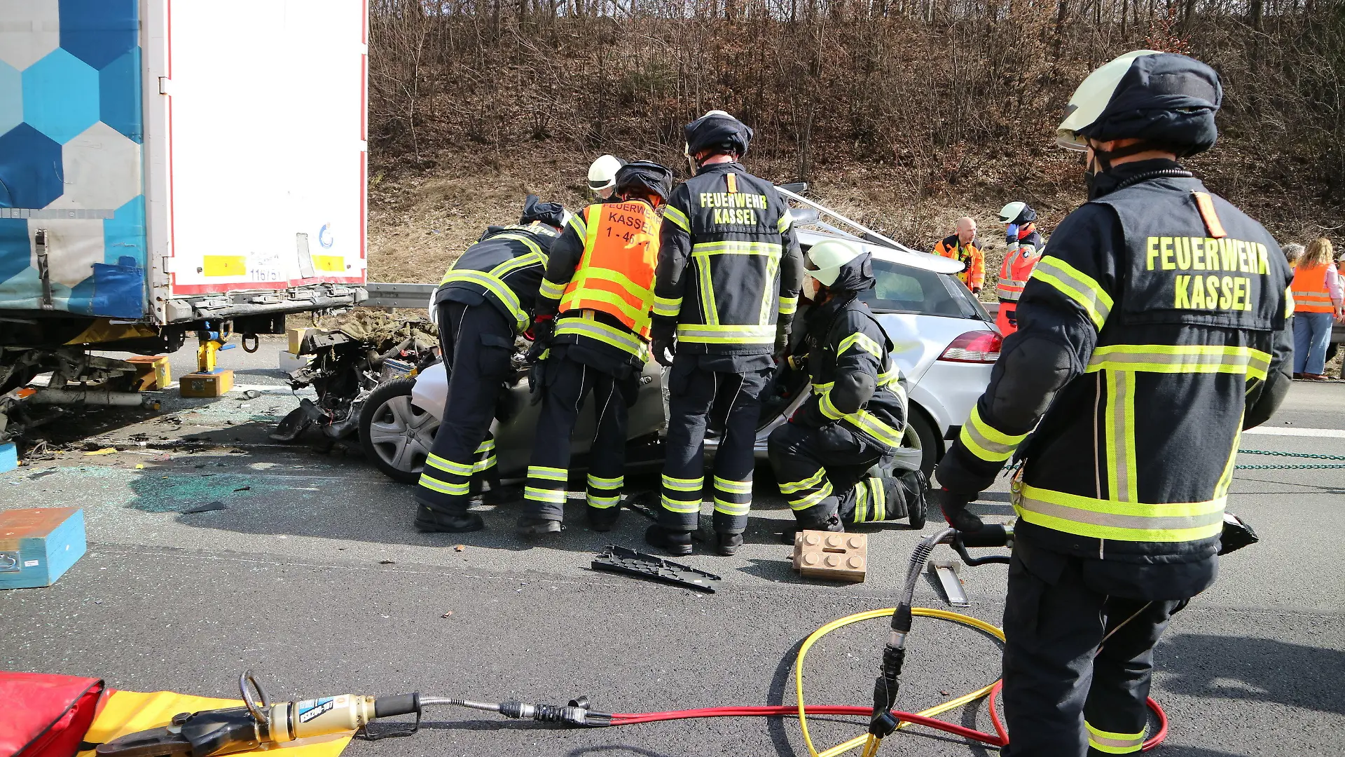 HANDOUT - 18.03.2023, Niedersachsen, Göttingen: Einsatzkräfte der Feuerwehr sind am Unfallort auf der Autobahn A7 nahe Göttingen. Bei dem schweren Auffahrunfall sind eine Mutter und ihr achtjähriger Sohn ums Leben gekommen. Die dreijährige Tochter der Frau, die mit in dem Kleinwagen saß, wurde schwer, aber nicht lebensgefährlich verletzt, wie eine Polizeisprecherin am Samstag sagte. Foto: ---/Feuerwehr Kassel/dpa - ACHTUNG: Nur zur redaktionellen Verwendung im Zusammenhang mit der aktuellen Berichterstattung und nur mit vollständiger Nennung des vorstehenden Credits +++ dpa-Bildfunk +++