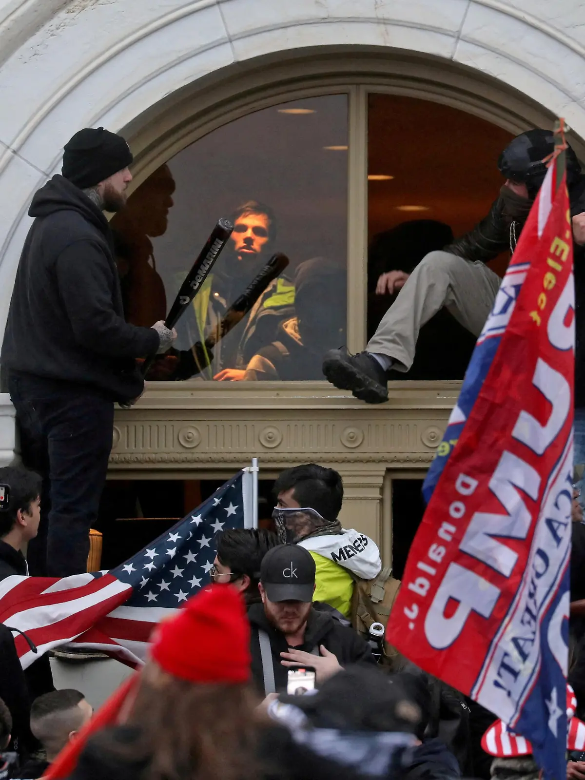 FILE PHOTO: A mob of supporters of then-U.S. President Donald Trump climb through a window they broke as they storm the U.S. Capitol Building in Washington, U.S., January 6, 2021. REUTERS/Leah Millis/File Photo