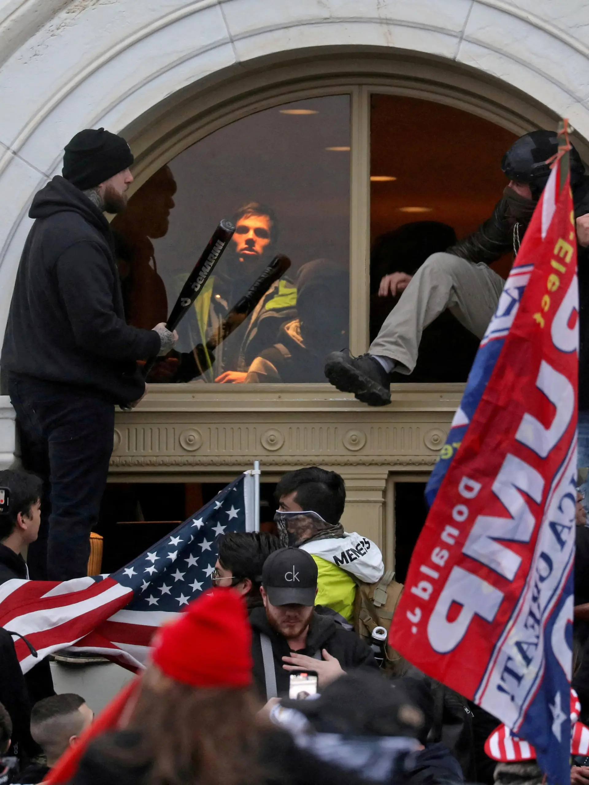 FILE PHOTO: A mob of supporters of then-U.S. President Donald Trump climb through a window they broke as they storm the U.S. Capitol Building in Washington, U.S., January 6, 2021. REUTERS/Leah Millis/File Photo