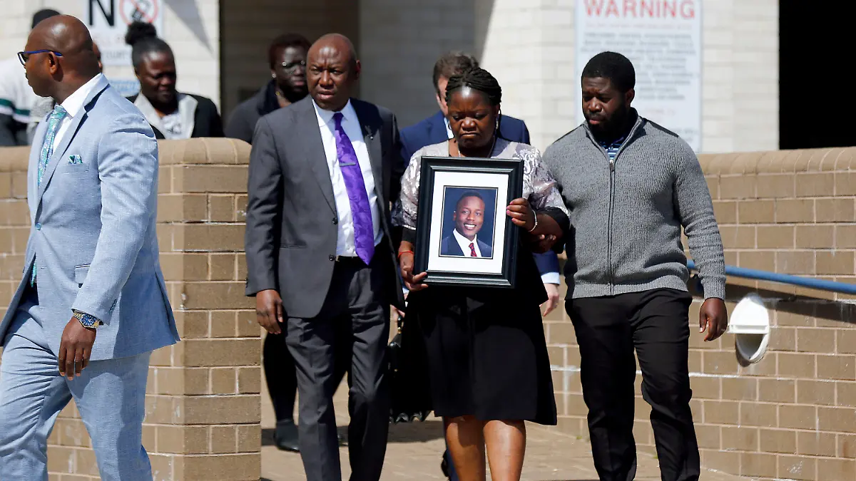 16.03.2023, USA, Dinwiddie: Caroline Ouko, Mutter von Irvo Otieno, hält ein Porträt ihres Sohnes, als sie zusammen mit ihrem Anwalt Ben Crump (M, l) und ihrem älteren Sohn Leon Ochieng das Dinwiddie Courthouse verlässt. Anderthalb Wochen nach dem brutalen Tod eines 28-jährigen Schwarzen in einer psychiatrischen Klinik im US-Bundesstaat Virginia haben seine Angehörigen schwere Vorwürfe gegen die Polizei erhoben. Foto: Daniel Sangjib Min/Richmond Times-Dispatch/AP +++ dpa-Bildfunk +++