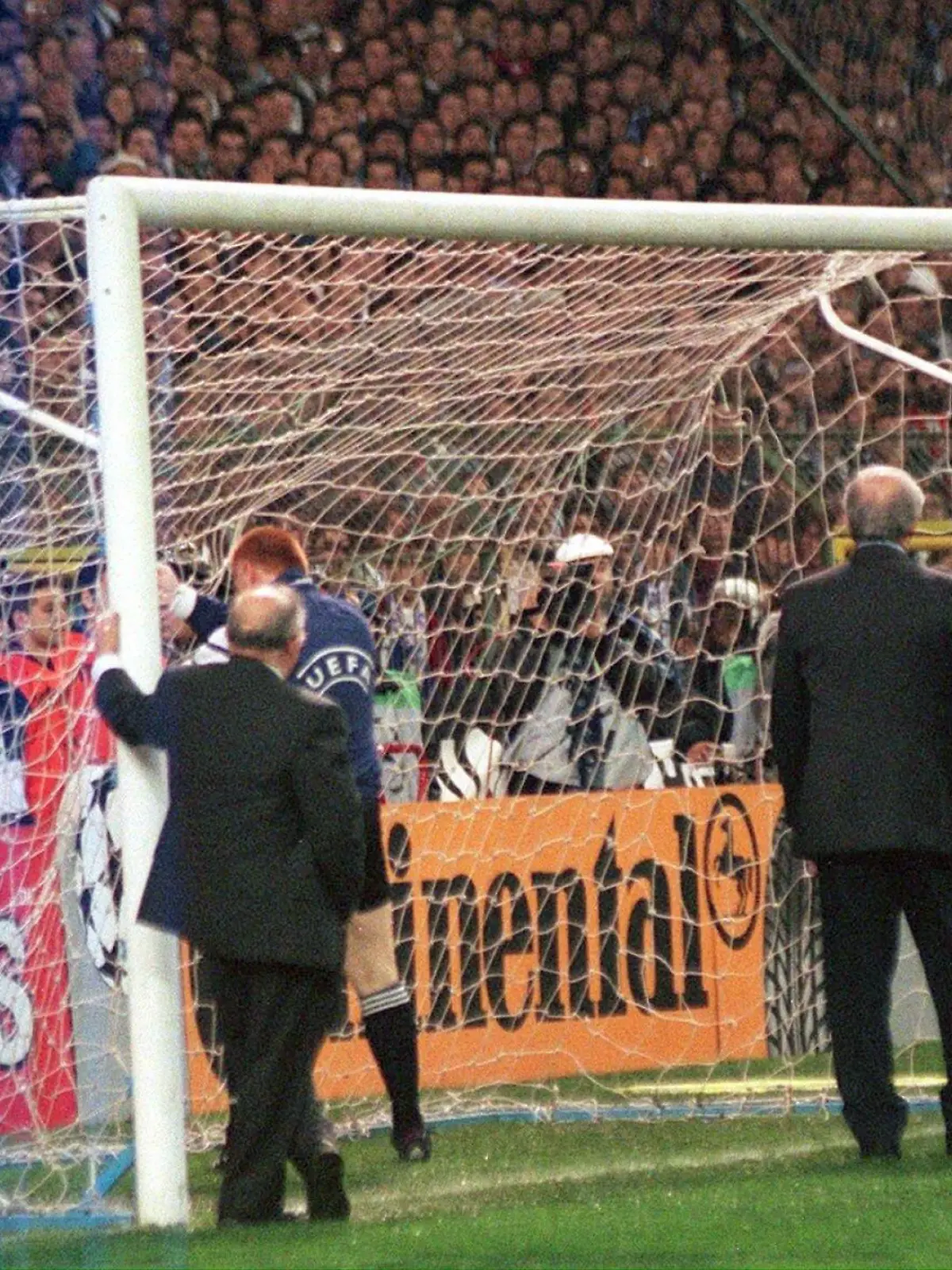 Der niederländische Schiedsrichter Mario van der Ende und UEFA-Offizielle inspizieren am 1.4.1998 im Santiago-Bernabeu-Stadion von Madrid das gerade aufgestellte neue Fußballtor, und 90.000 schauen zu. Es muß das von gewalttätigen Hooligans zerstörte Gehäuse vor der Südtribüne ersetzt werden. Es dauert 75 Minuten, ehe das Tor herangeschafft und aufgerichtet ist und das Halbfinal-Hinspiel zwischen dem spanischen Meister Real Madrid und Cupverteidiger Borussia Dortmund (2:0) beginnen kann. Für den Tor-Schaden wird die berüchtigte Madrilener Fan-Gruppe "Ultrasur" verantwortlich gemacht. Mitglieder dieser Gruppe hängten sich an einen Sicherheitszaun und brachten damit das mit dem Zaun verbundene Tor zum Einsturz.