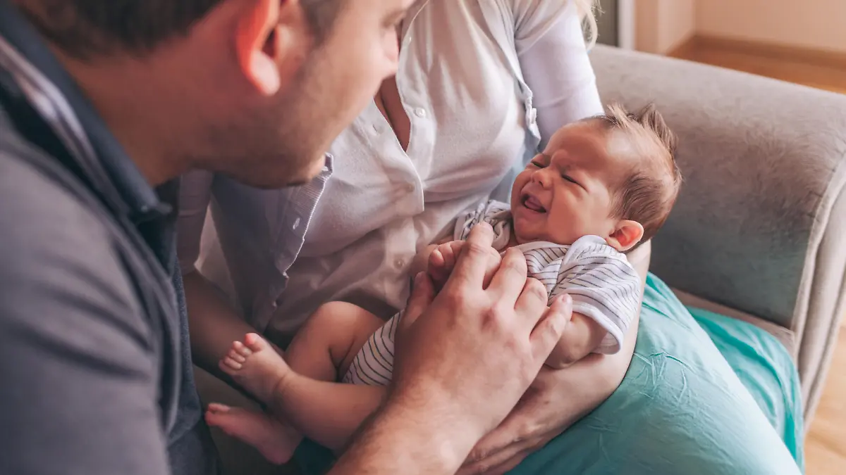 Vater und Mutter beruhigen weinendes Baby