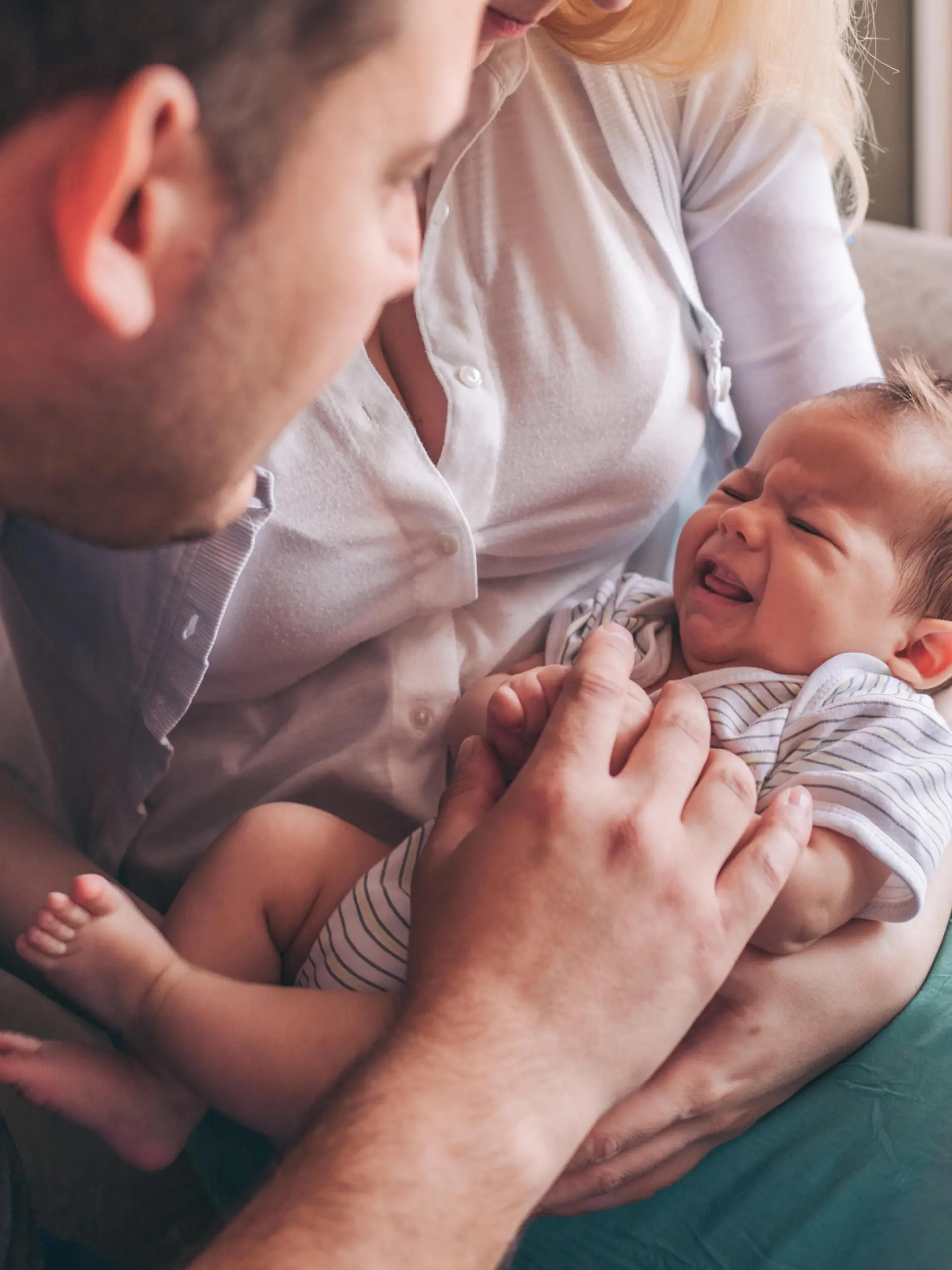 Vater und Mutter beruhigen weinendes Baby