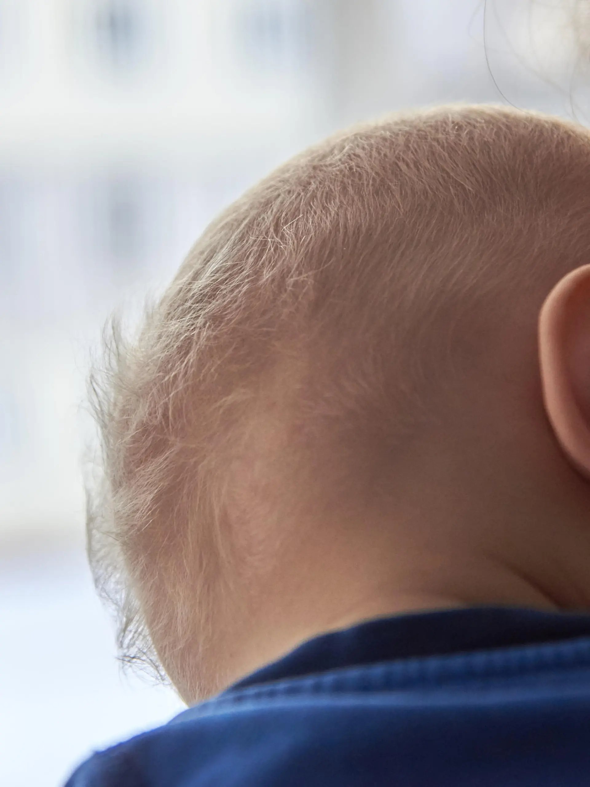 Mutter hält Baby mit dünnem Haar im Arm