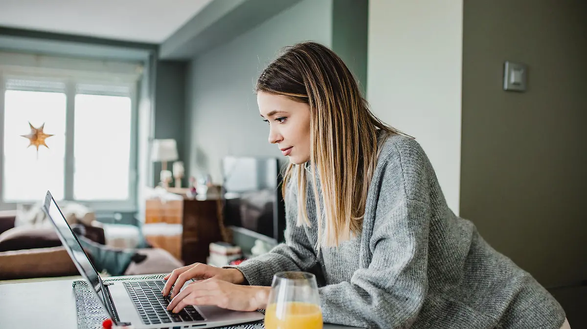 Frau sitzt am Laptop zu Hause
