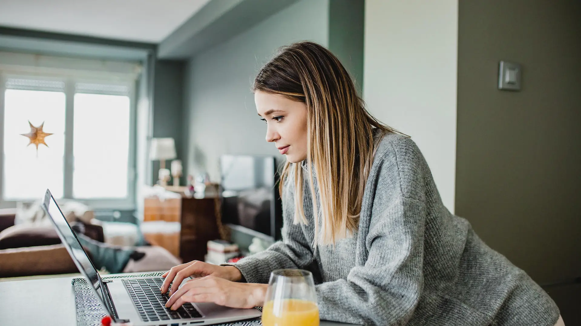 Frau sitzt am Laptop zu Hause