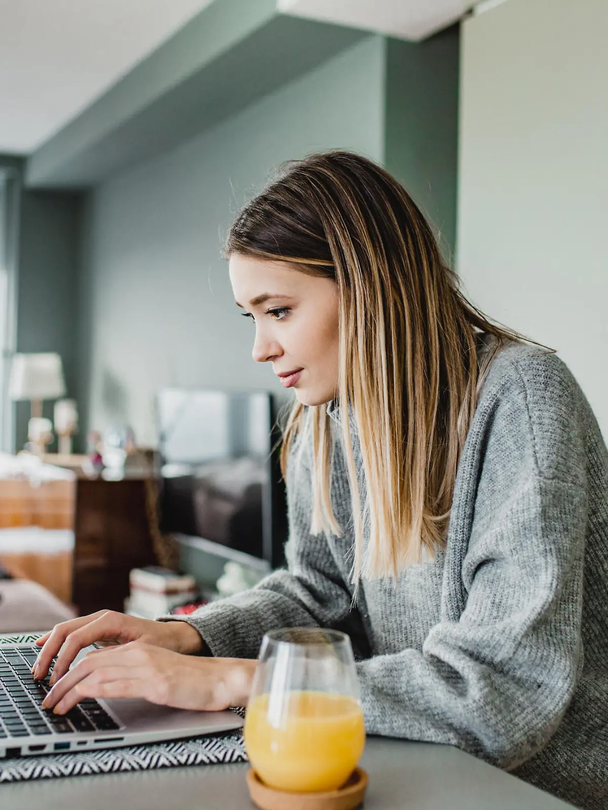 Frau sitzt am Laptop zu Hause