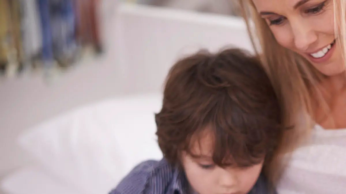 Shot of a mother reading with her children at home