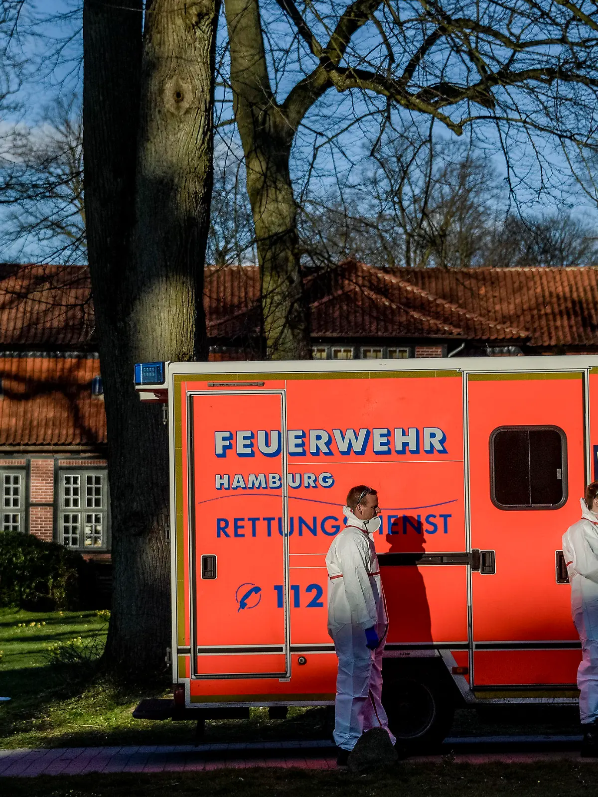 31.03.2020, Hamburg: Rettungssanitäter der Hamburger Feuerwehr warten vor einem Altenheim, in dem mehrere Bewohner positiv auf den Covid-19-Virus getestet worden sind. Foto: Axel Heimken/dpa +++ dpa-Bildfunk +++