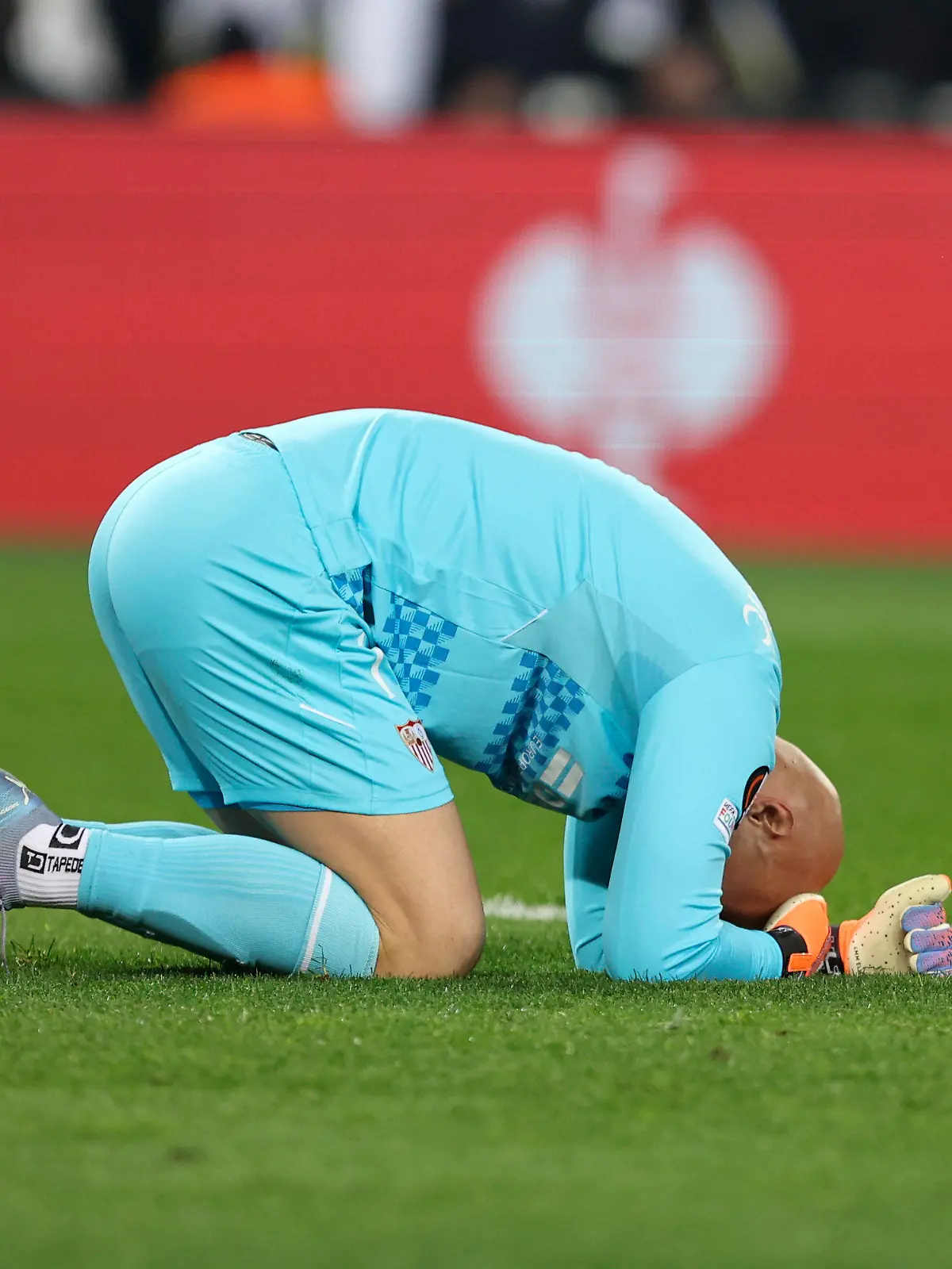 Sevilla's goalkeeper Marko Dmitrovic lies on the field during the Europa League round of 16 second leg soccer match between Fenerbahce and Sevilla at Sukru Saracoglu stadium in Istanbul, Turkey, Thursday, March 16, 2023. (AP Photo)