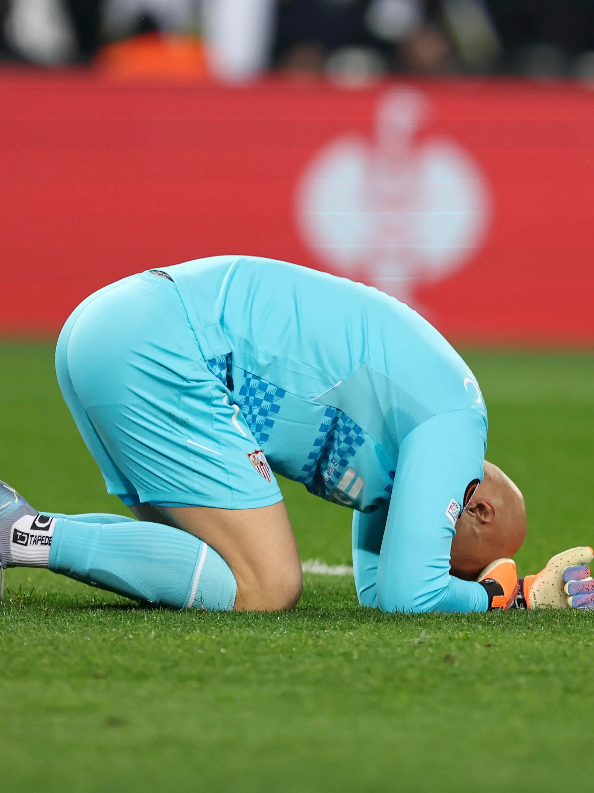 Sevilla's goalkeeper Marko Dmitrovic lies on the field during the Europa League round of 16 second leg soccer match between Fenerbahce and Sevilla at Sukru Saracoglu stadium in Istanbul, Turkey, Thursday, March 16, 2023. (AP Photo)