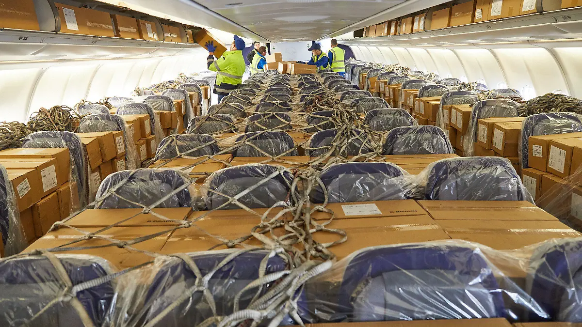 HANDOUT - 27.03.2020, Hessen, Frankfurt/Main: Der Logistikdienstleister DB Schenker und Lufthansa Cargo haben 2.780.000 Atemschutzmasken an die Landesregierung von Hessen geliefert. Die 12,7 Tonnen medizinisches Material erreichten aus Schanghai kommend den Frankfurter Flughafen. Um die rund 6.000 Kartons in dem Passagierflugzeug vom Typ A330 unterzubekommen, wurden auch die Sitzreihen in der Kabine sowie die Staufächer über den Sitzen bepackt. Foto: Deutsche Bahn AG/Lufthansa Cargo/dpa - ACHTUNG: Nur zur redaktionellen Verwendung im Zusammenhang mit der aktuellen Berichterstattung und nur mit vollständiger Nennung des vorstehenden Credits +++ dpa-Bildfunk +++