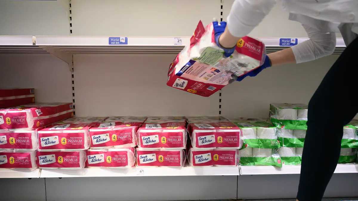 ARCHIV - 18.03.2020, Baden-Württemberg, Stuttgart: Eine Mitarbeiterin räumt in einem Drogeriemarkt der Kette dm-drogerie markt Toilettenpapier ein. Aufgrund der Ausbreitung des Coronaviruses kaufen Kunden momentan stärker ein. (zu dpa: «Drogeriemarktkette: Mangel an Toilettenpapier bald beendet») Foto: Sebastian Gollnow/dpa +++ dpa-Bildfunk +++