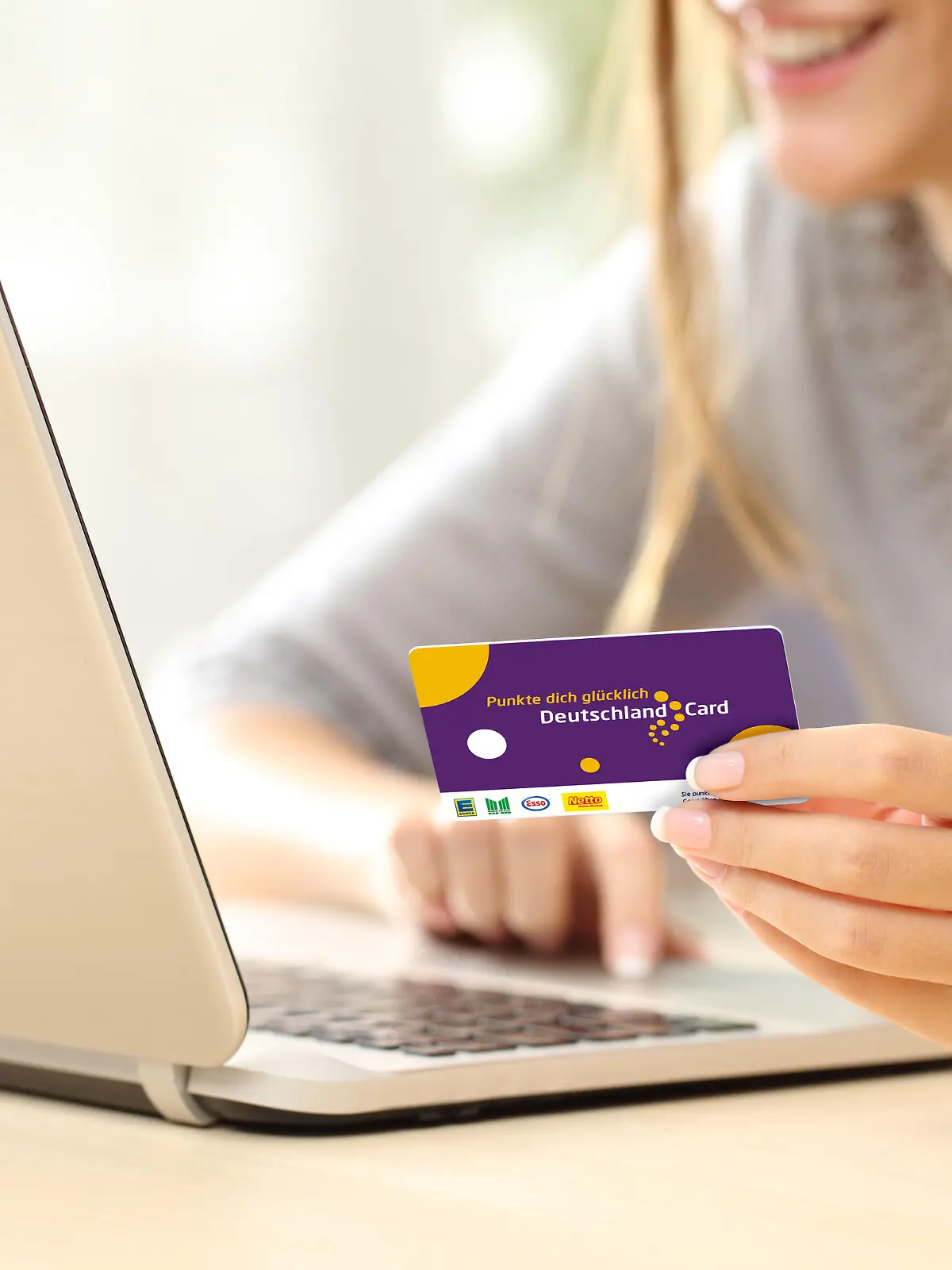Close up of a happy woman hand buying online with a laptop and paying with a credit card