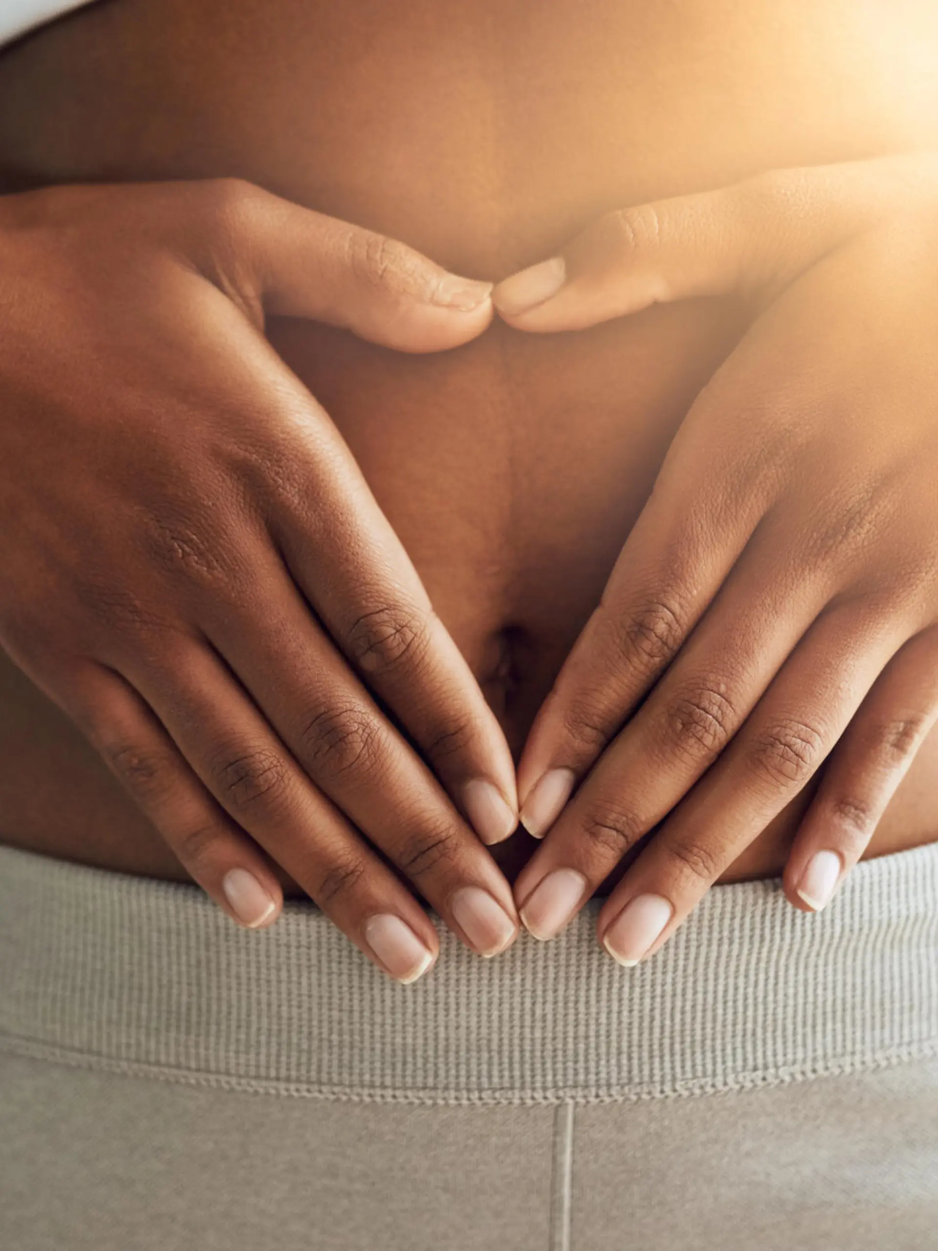 Cropped shot of a sporty young woman making a heart with her hands on her stomach