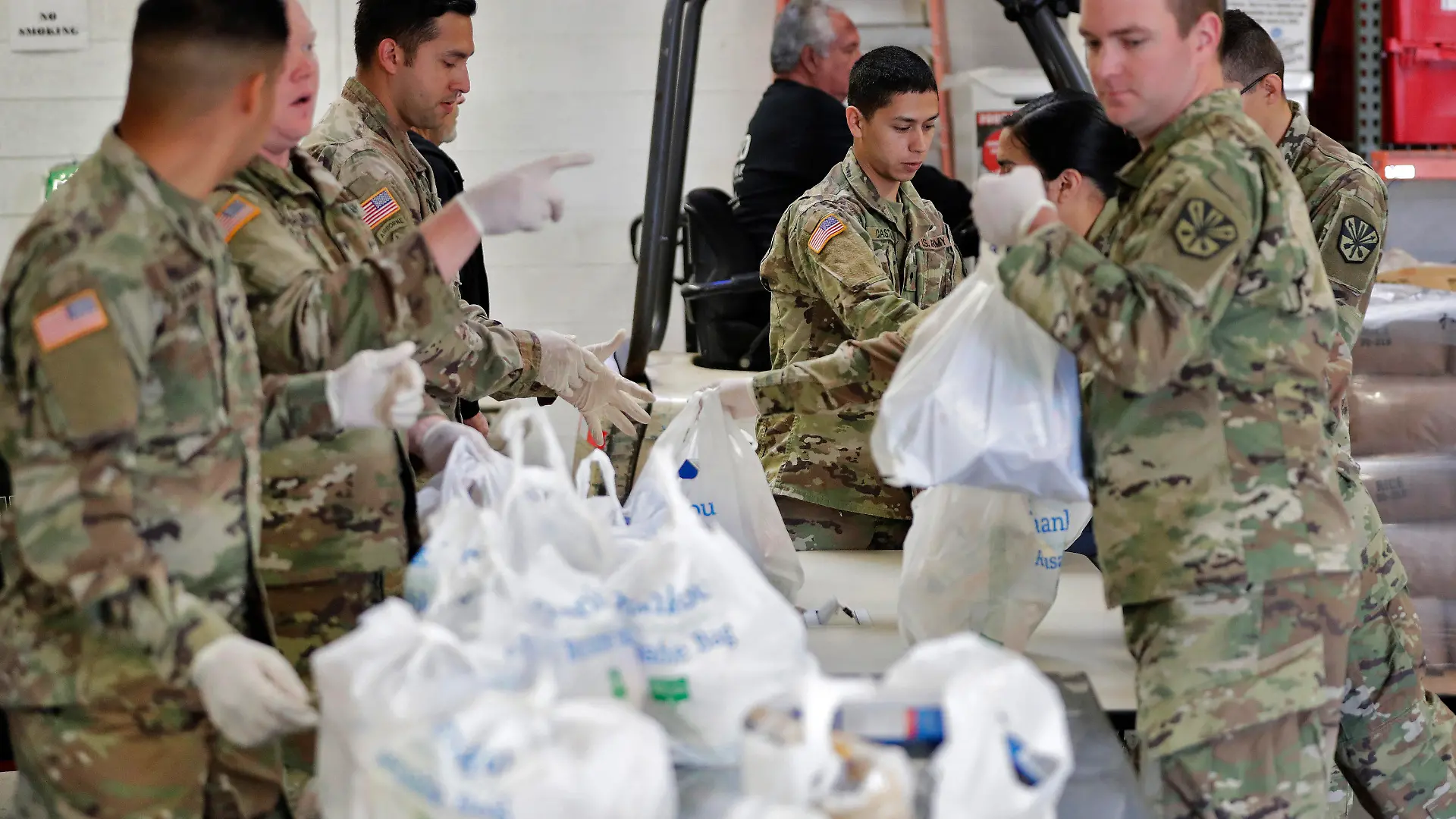 26.03.2020, USA, Mesa: Mitglieder der Nationalgarde von Arizona packen und sortieren Lebensmittel in einer Lebensmittelbank Foto: Matt York/AP/dpa +++ dpa-Bildfunk +++