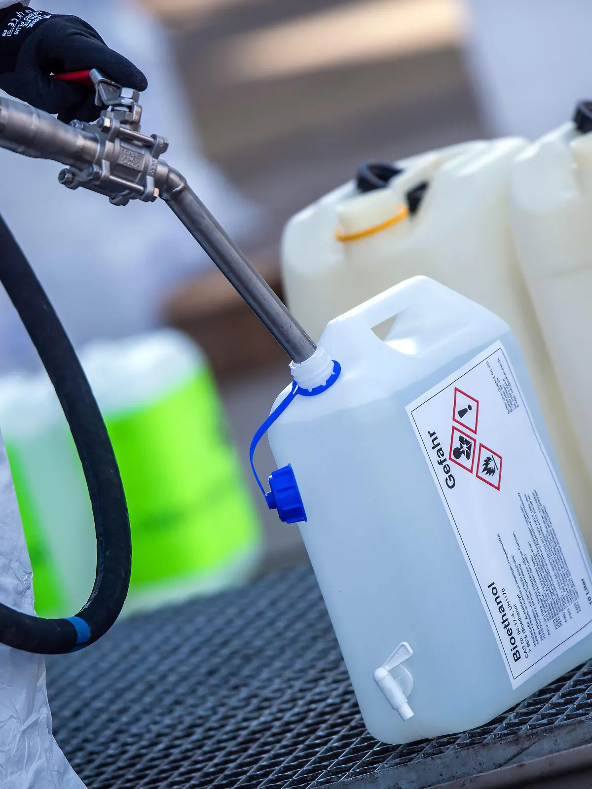 25.03.2020, Mecklenburg-Vorpommern, Anklam: Mitarbeiter füllen auf dem Gelände des Zuckerwerks Kanister mit Ethanol für den Verkauf an Apotheker ab. Das Ethanol wird für die Herstellung von Desinfektionsmittel zum Schutz vor dem Coronavirus genutzt. Bei der ersten Auslieferung in der vergangenen Woche wurden nach Angaben der Firma rund 5.000 Liter verteilt. Wegen Lieferengpässen dürfen Apotheker selbst Desinfektionsmittel herstellen und müssen sich dafür die Bestandteile selbst organisieren. Foto: Jens Büttner/dpa-Zentralbild/dpa +++ dpa-Bildfunk +++