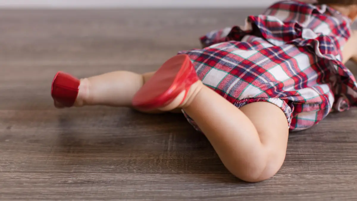 Baby macht seine ersten Krabbelversuche mit Krabbelschuhen