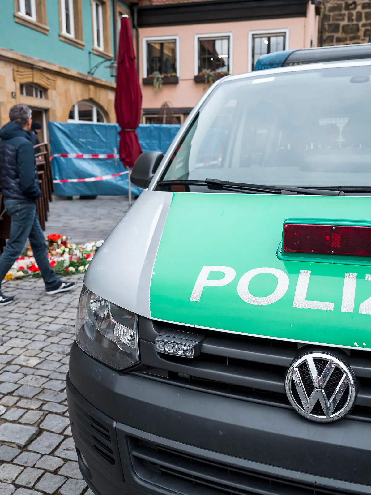 13.03.2023, Bayern, Lichtenfels: Ein Einsatzwagen der Polizei steht vor dem Blumengeschäft, in dem am Freitagabend eine leblose Frau aufgefunden wurde. Spaziergänger hatten die tote 50-Jährige in dem Blumenladen in der Lichtenfelser Innenstadt entdeckt. Foto: Daniel Vogl/dpa +++ dpa-Bildfunk +++