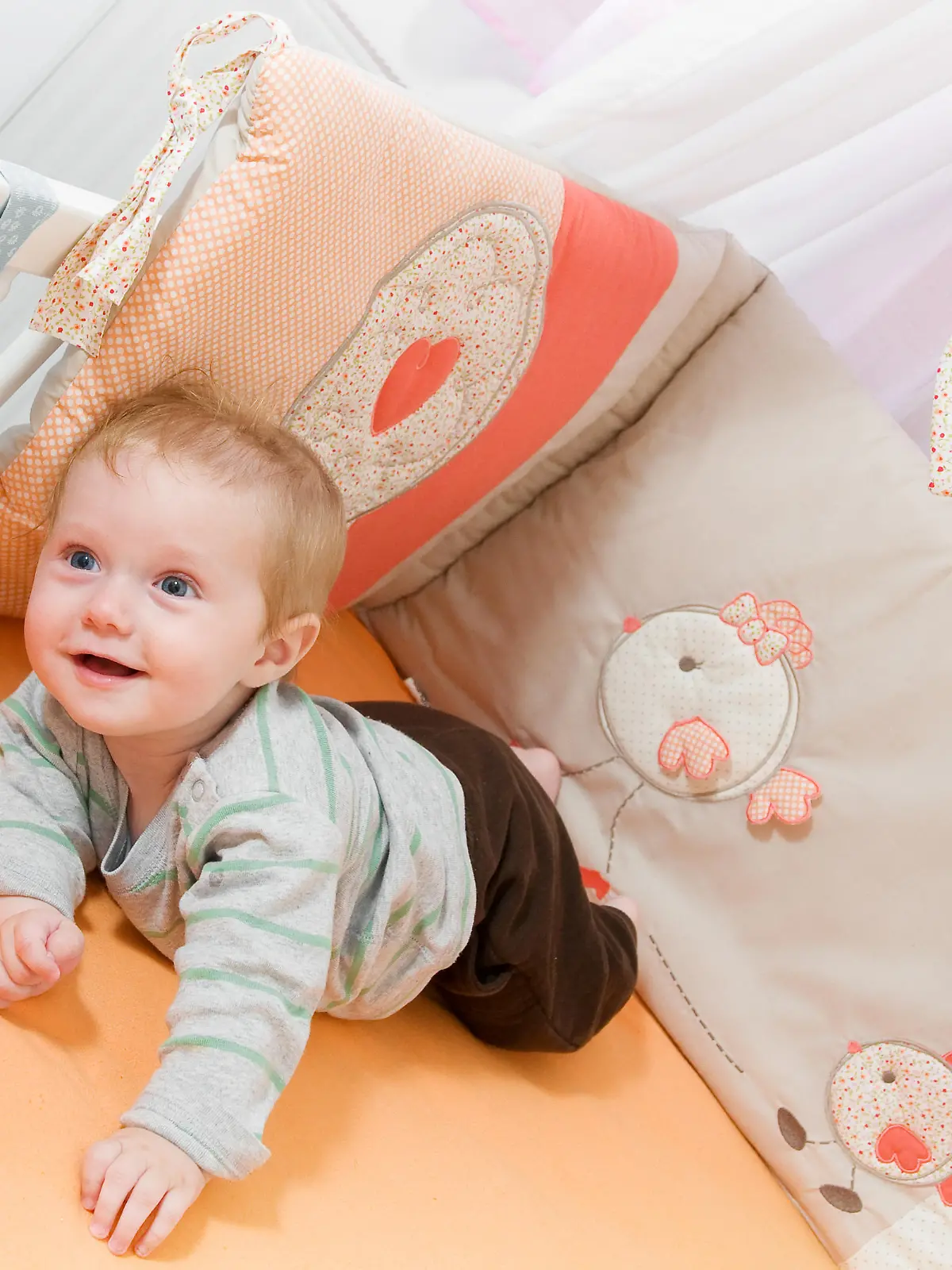 Baby liegt im Bettchen mit Bettgitter