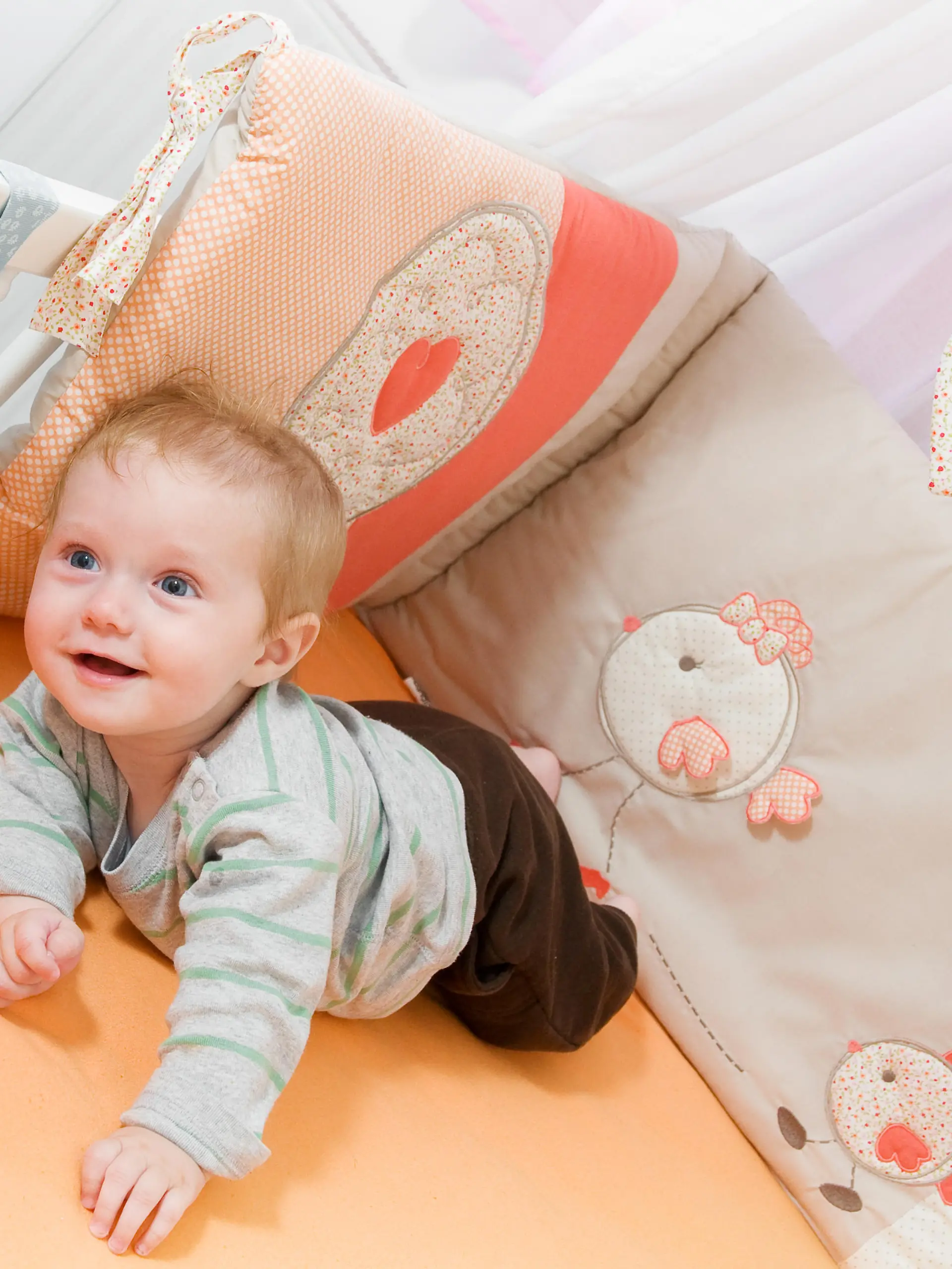 Baby liegt im Bettchen mit Bettgitter