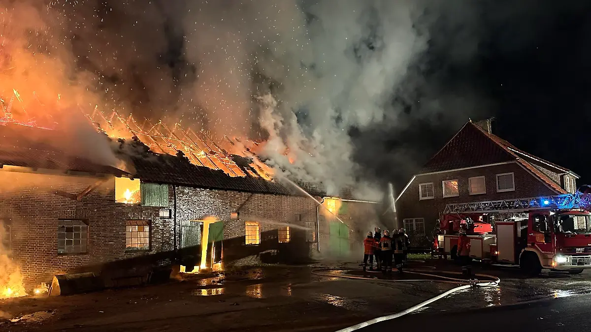 Blick auf die Scheune mit dem Wohnhaus im Hintergrund. Die Drehleiter aus Zeven wird gerade in Stellung gebracht