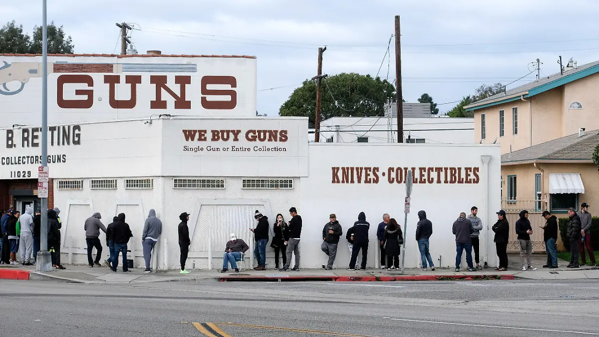 15.03.2020, USA, Culver City: Menschen warten in einer langen Schlange vor einem Waffenladen in Zeiten der raschen Ausbreitung des neuartigen Coronavirus im Land. Einige Wartende wollen sich mit Munition eindecken, während andere sagten, sie würden Waffen zu ihrem Schutz kaufen, falls ihre Häuser für Lebensmittel und andere Notwendigkeiten überfallen werden sollten. Foto: Ringo H.W. Chiu/AP/dpa +++ dpa-Bildfunk +++