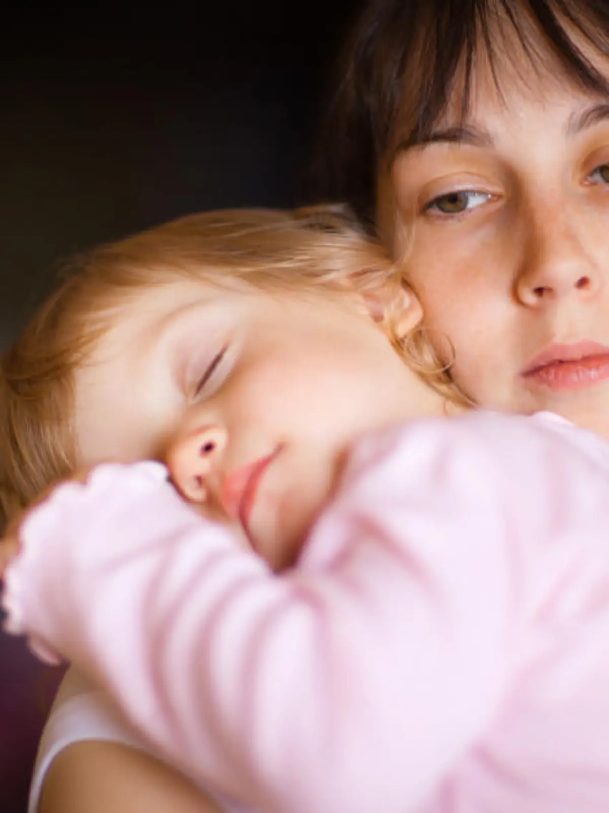 Sleepy little child with mom - shallow DOF, focus on woman\'s eyes