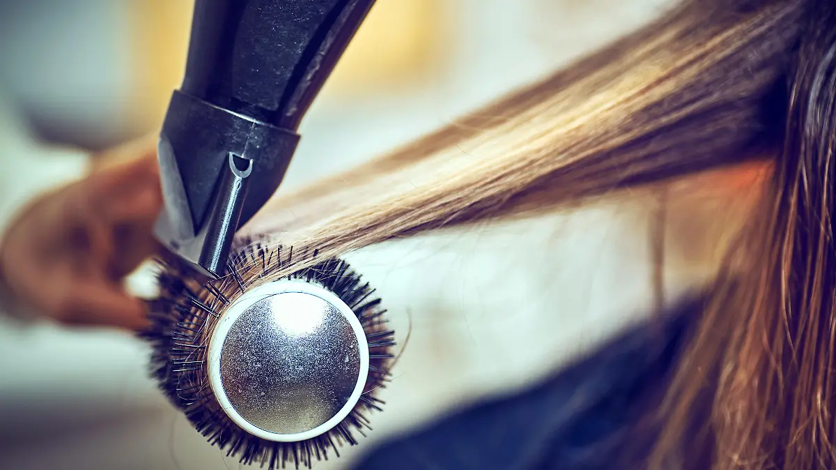 Professional hairdresser drying hair, in ctudio