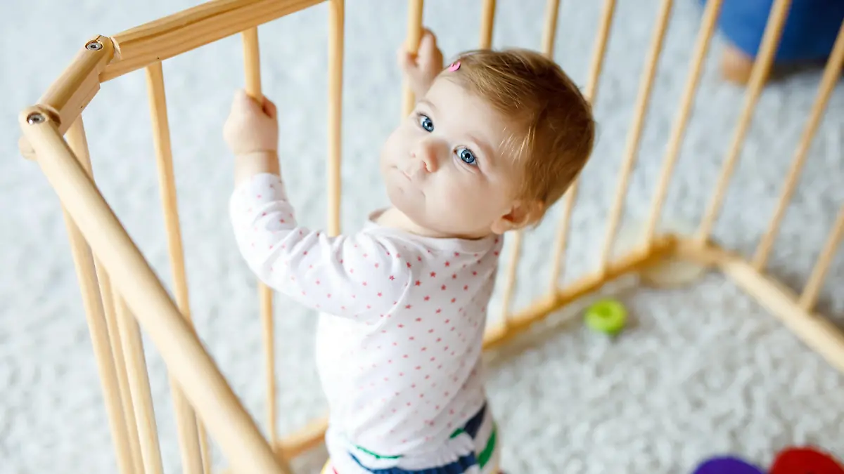 Baby spielt und macht seiner ersten Gehversuche im Laufgitter