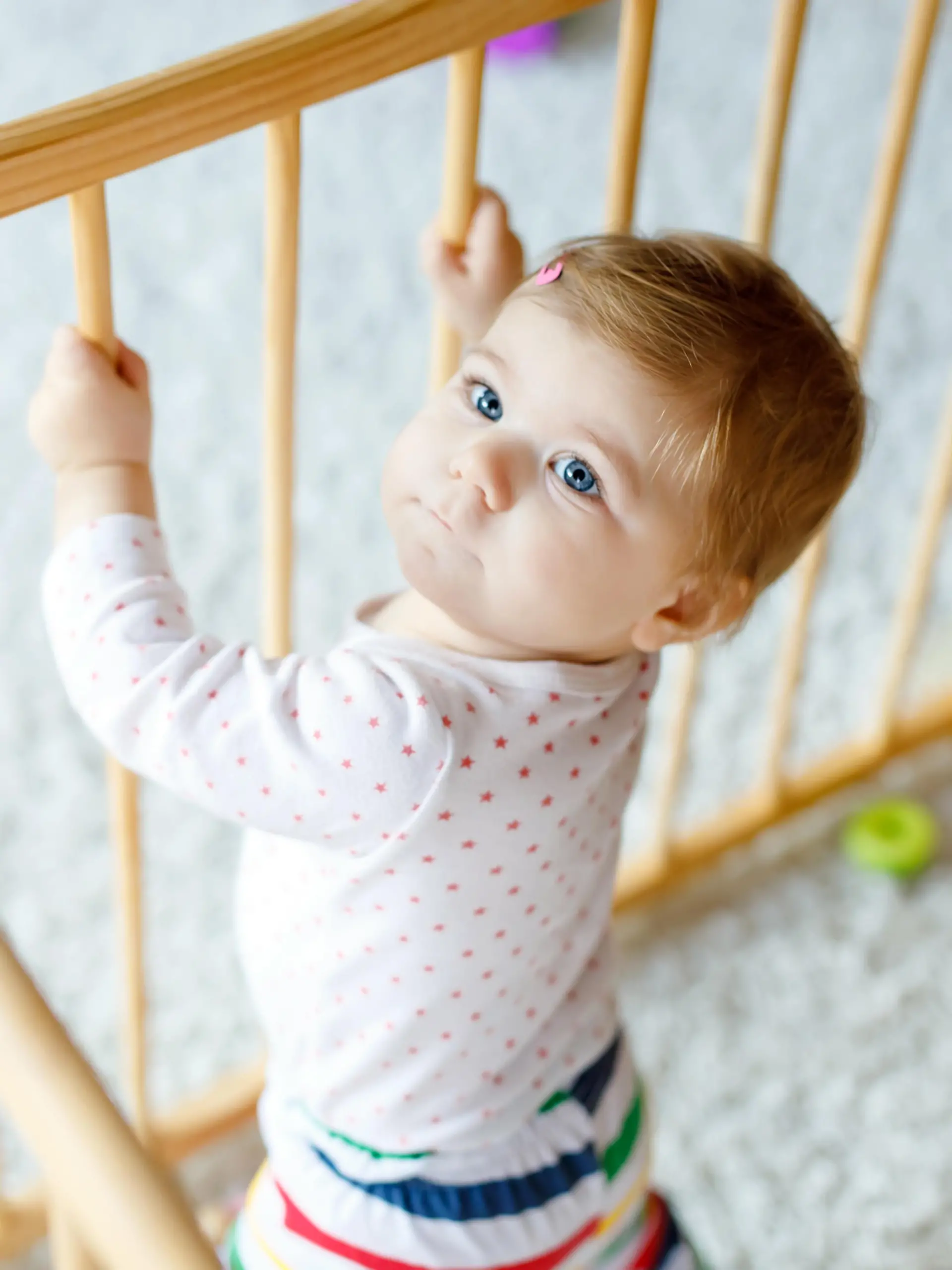 Baby spielt und macht seiner ersten Gehversuche im Laufgitter