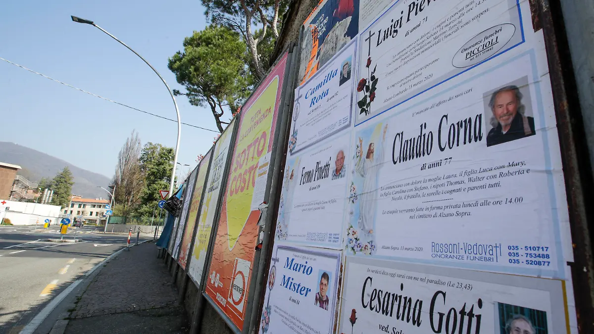 15.03.2020, Italien, Alzano Lombardo: Todesanzeigen sind auf einer Tafel entlang einer leeren Straße in Alzano Lombardo, in der Nähe von Bergamo zu sehen. In der Lombardei liegen die Metropole Mailand und die heftig von der Krankheit Covid-19 betroffene Zone um Bergamo. (zu dpa «Wo nur noch Totenglocken läuten») Foto: Luca Bruno/AP/dpa +++ dpa-Bildfunk +++
